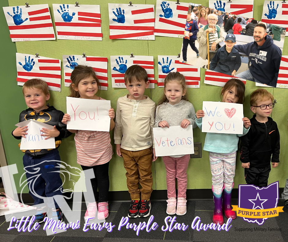 students smiling and holding "thank you veterans" signs